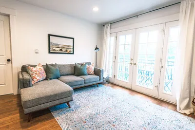 A large gray sectional and double doors leading to the deck