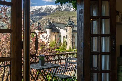 Castle viewed through open French doors with snow-capped Mount Timpanogos in the background